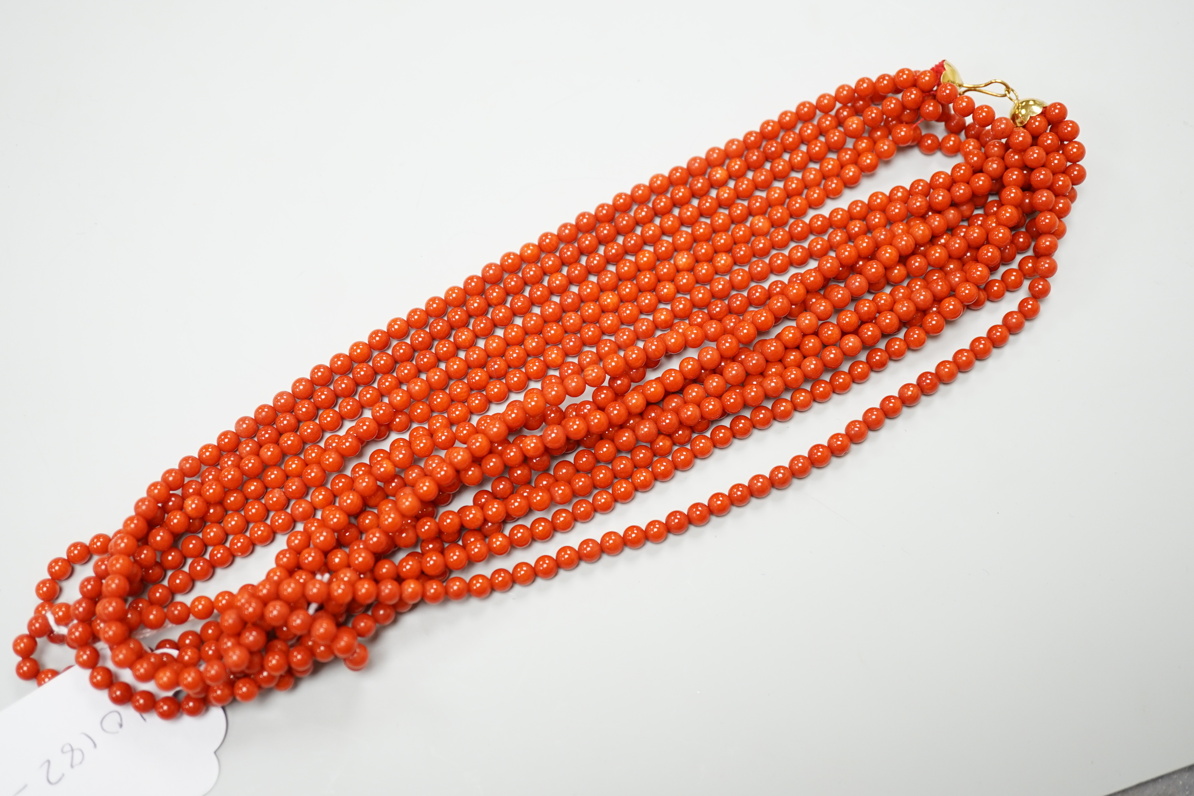 A 1980's Italian multi strand coral bead necklace, with 750 yellow metal clasp and Certificate of Authenticity, 50cm.